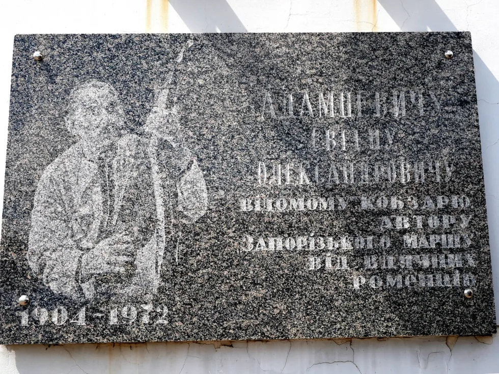 Гранітна дошка з різьбленим портретом кобзаря з бандурою і роками 1904–1972